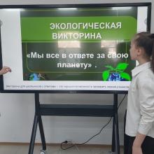 Two young girls with a screen showing information about the eco-centre.
