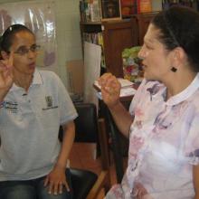 A  library trainee practises sign language with a librarian.