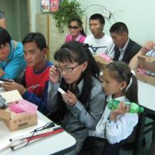 Blind and visually impaired people open boxes with new DAISY readers.