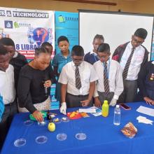 A group of youth mixing chemicals in glass dishes. 