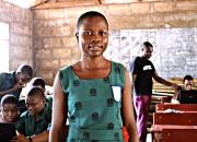 Young girl in school uniform in school classroom. 