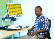 Young man, Gorata Matome, using large print on a computer screen. 