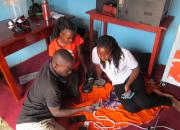 Peter Balaba, librarian at Nakaseke Public Library teaches two women how to use the internet on their smartphones. 