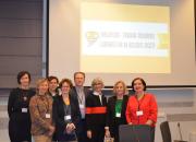 Group of delegates in front of screen with name of conference