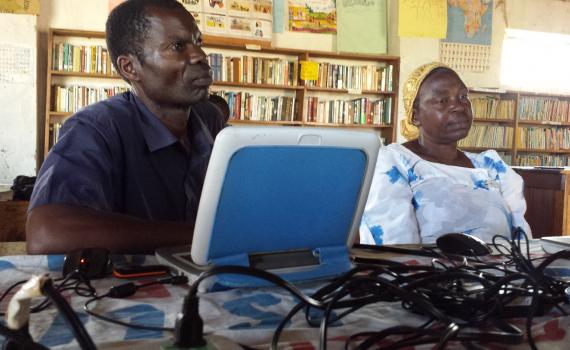 Two farmers learning computer skills in Caezaria Public Library in Uganda.