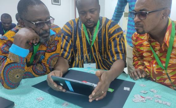 Three public librarians with a computer during EIFL and partners Training of Trainers programme in March 2024.