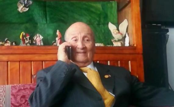 A happy elderly man on the phone to his Reader