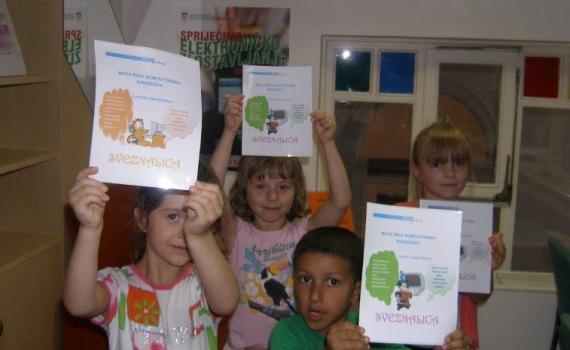 Roma and non-Roma children show off certificates for achievements in ICT training.