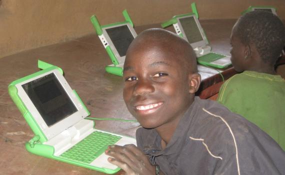Orphans and vulnerable children learn literacy skills in mother tongue using computer-based exercises developed by Lubuto Library Project. Children using laptop computers in the library.