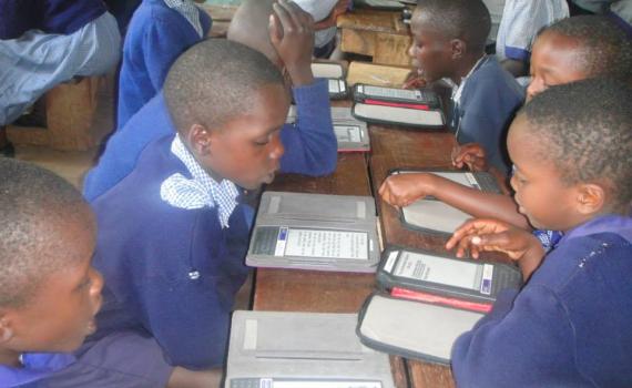 Reading aloud in class – children practice using the e-readers. Children in a classroom reading with the e-readers.
