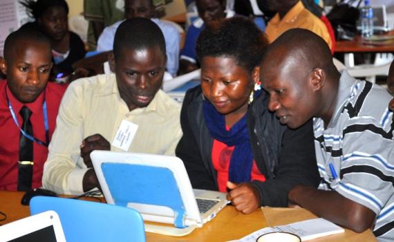 In the photo: three librarians learning computer skills, using a laptop.